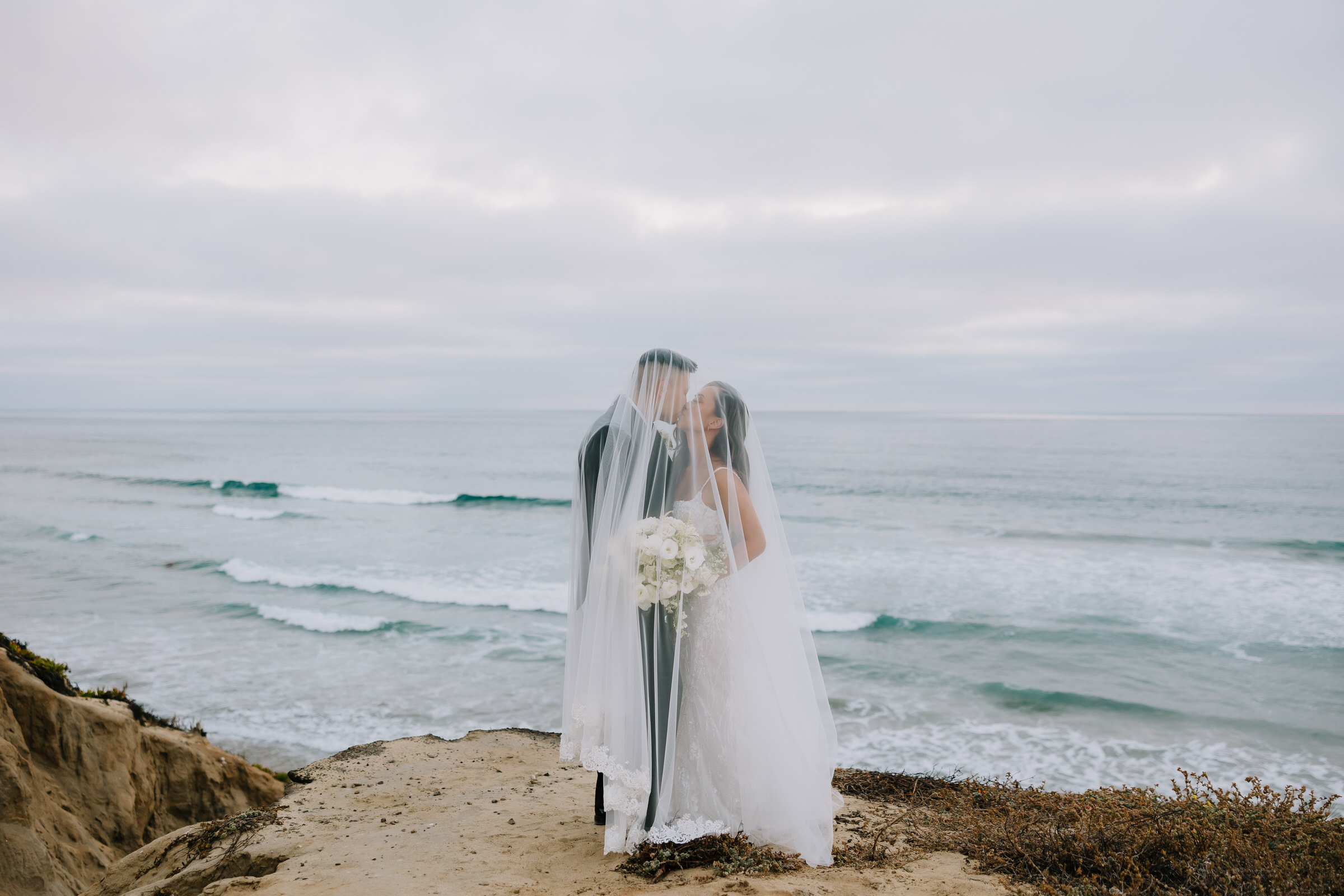 A romantic portrait of Allison and Carson during their Alila Marea Beach Resort wedding ceremony overlooking the Encinitas coastline.