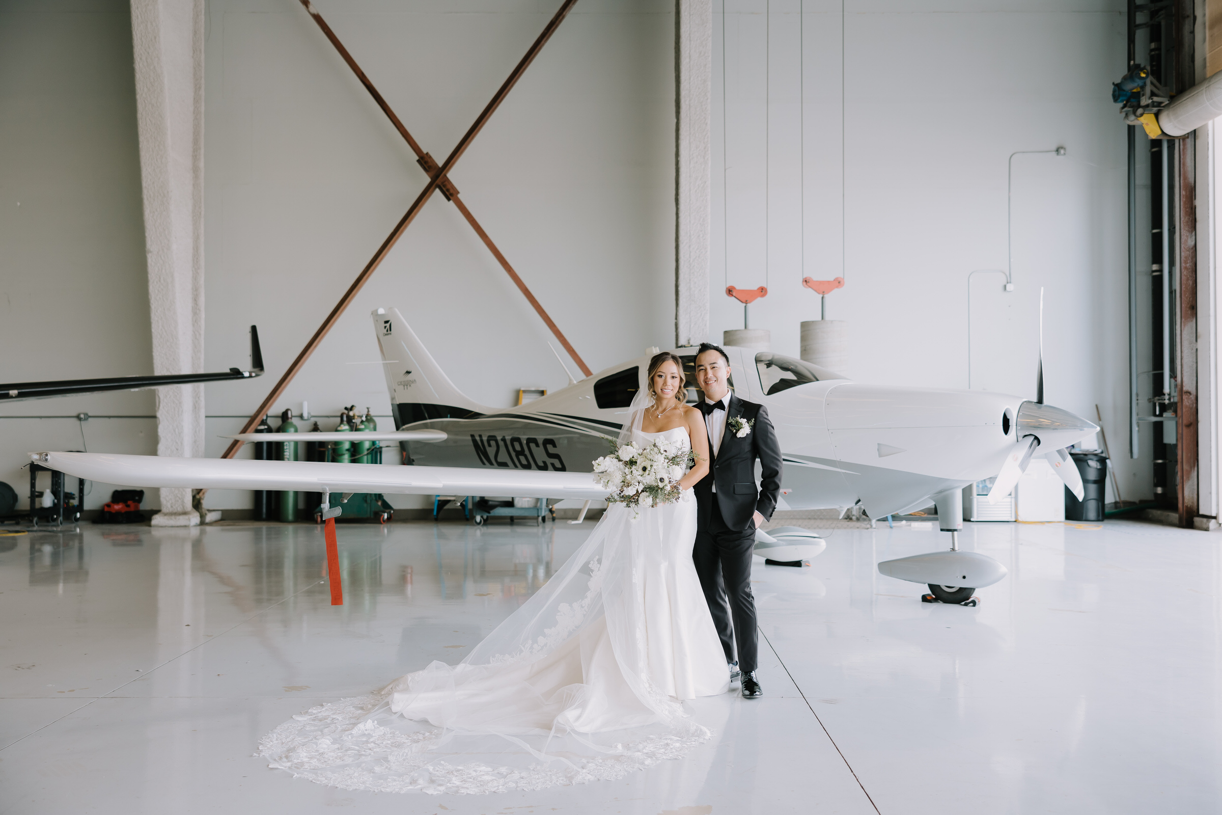 Allison and Thomas sharing a quiet moment on the outdoor terrace of The Modern Long Beach as a private jet sits on the runway below.