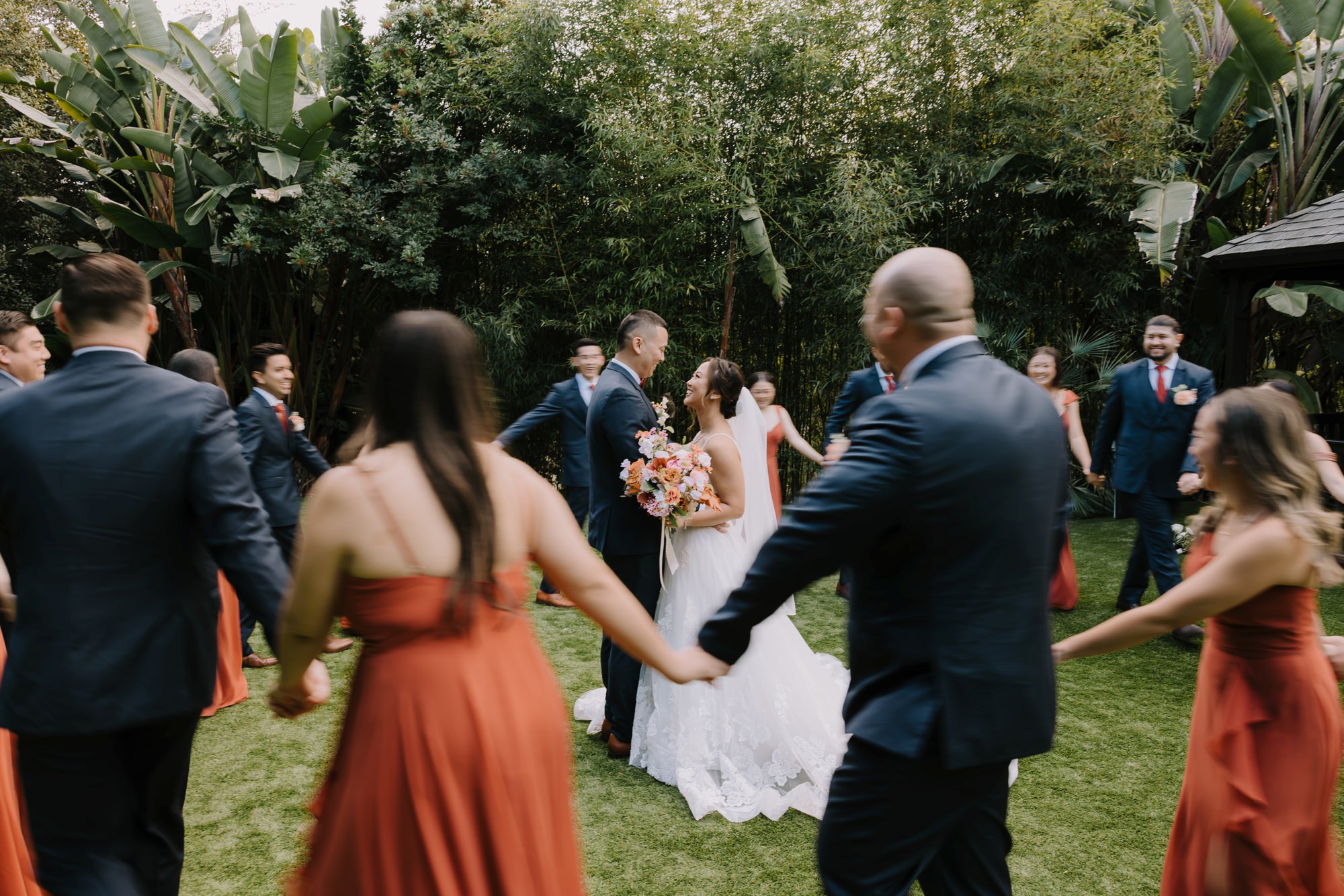 A romantic moment between Crystal and Jeff at their Botanica Oceanside wedding, surrounded by tropical palm trees and a beautiful pond.