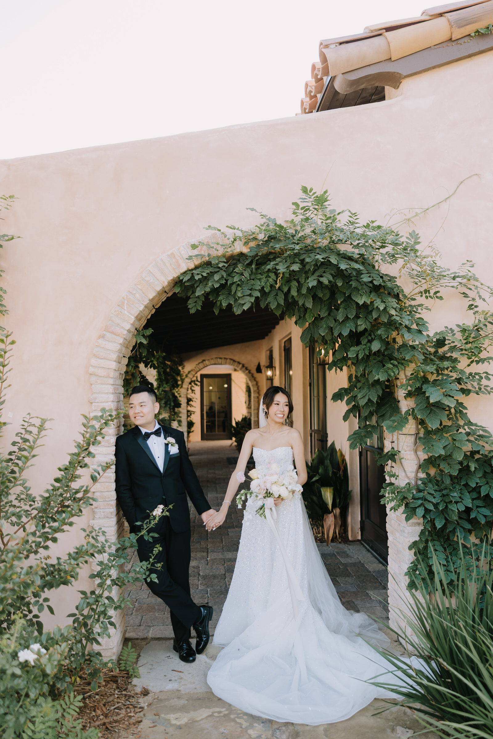 Jessie and Eric walking through the sun-drenched vineyards at Monserate Winery in Fallbrook during golden hour.