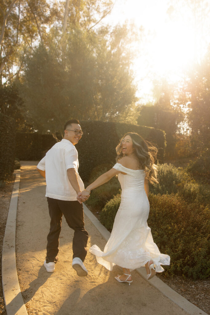Couple posing outdoors in chic attire for an Italian-inspired engagement session with mountain backdrop.