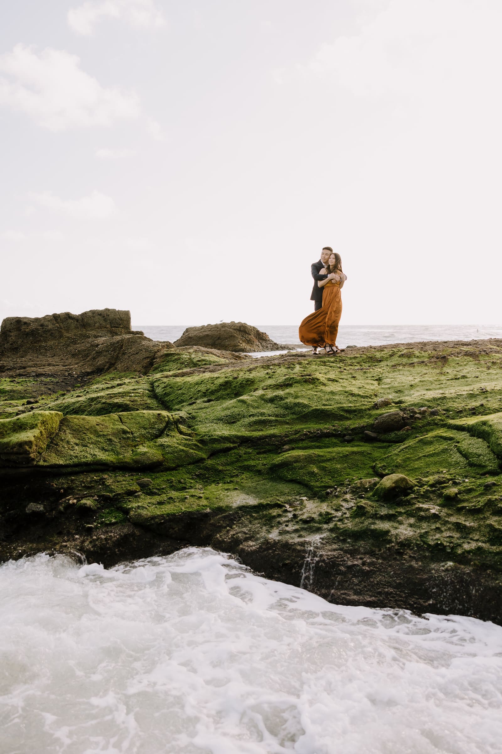 Vibrant green algae on coastal rocks during a low tide engagement session in California.