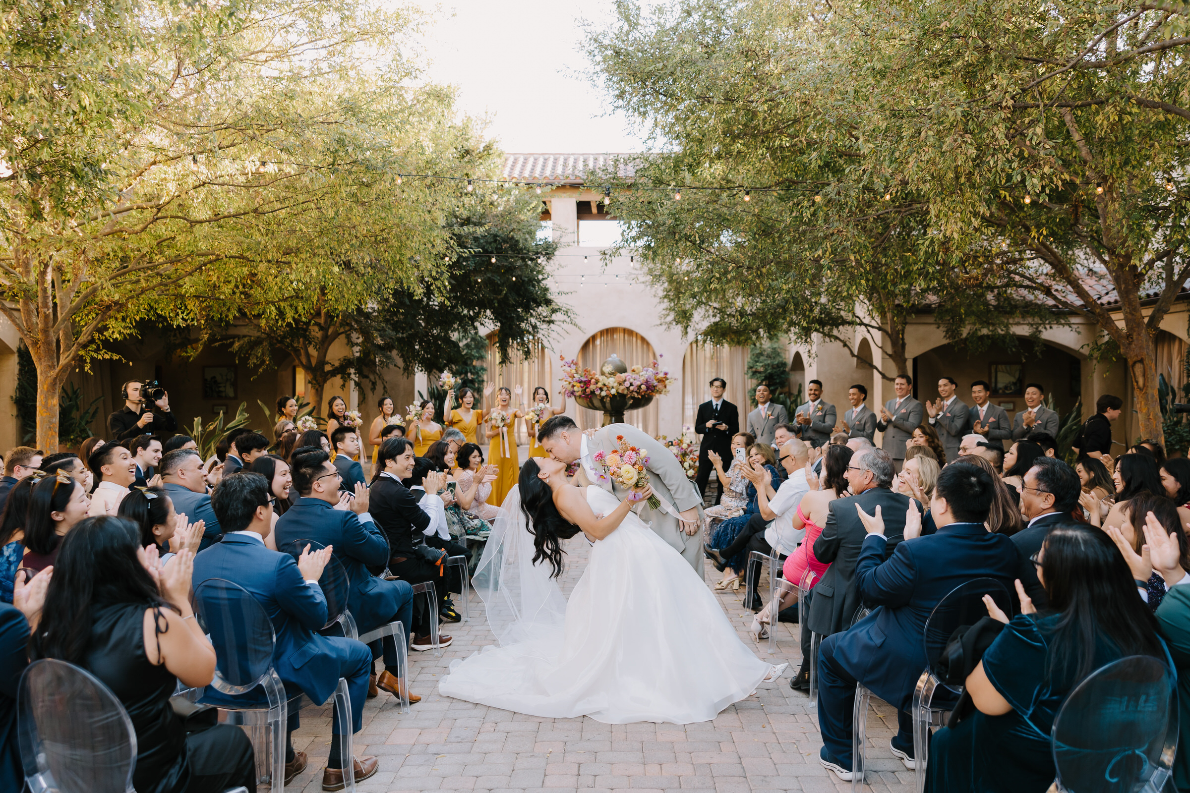 Alyssa and Marc posing under the historic arches of Mission San Juan Capistrano for their wedding portraits.