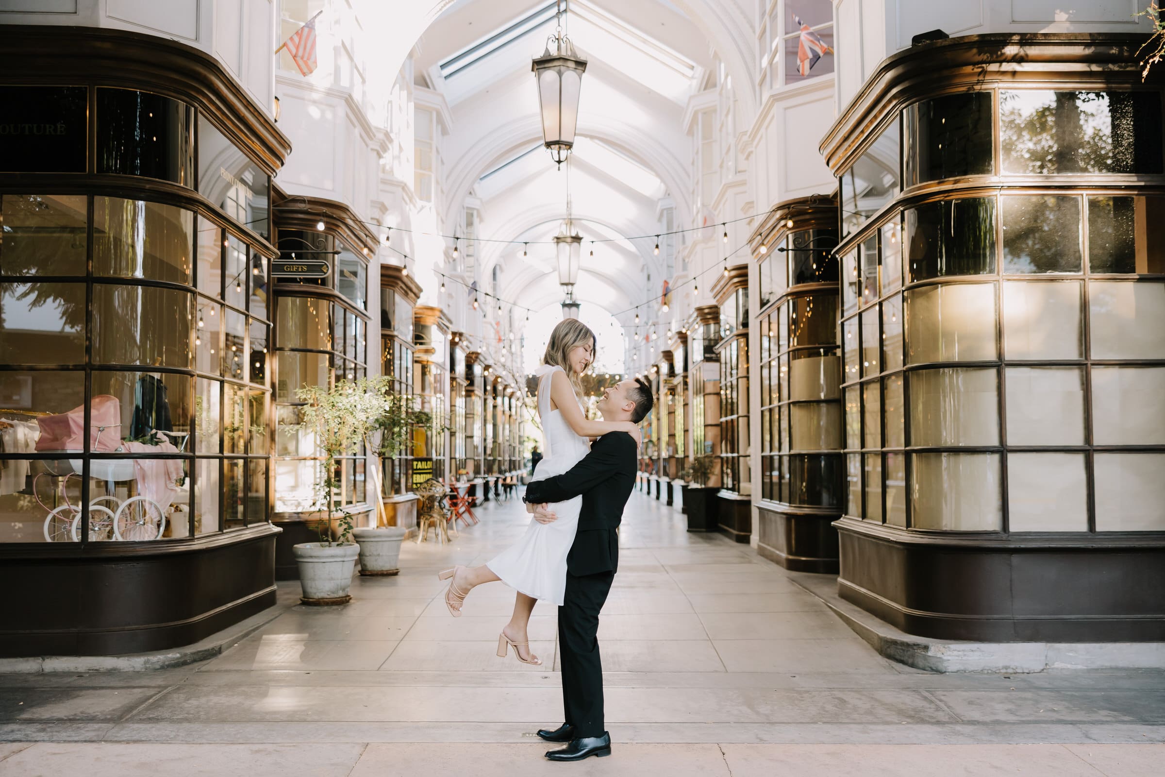 Rita and Brian walking through the London-style architecture of Burlington Arcade in Pasadena during their engagement session.