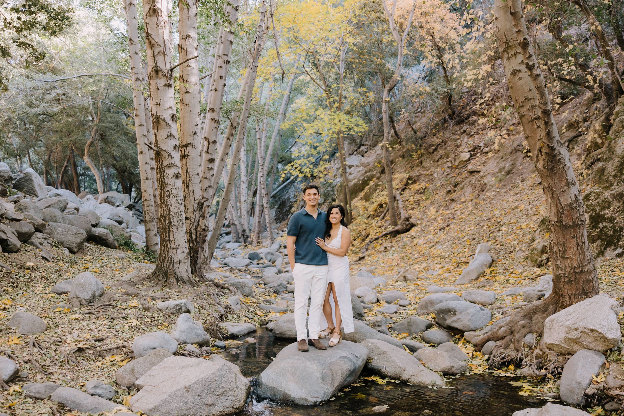 Celestine and Cameron embracing in the moody, candle-lit interior of The Obscure distillery in Los Angeles.