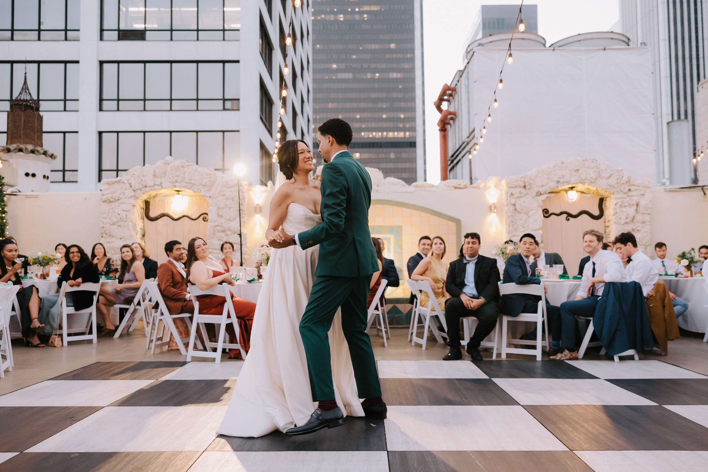 Judy and Jonathan sharing a kiss on the rooftop of the Oviatt Penthouse with the Los Angeles skyline in the background.