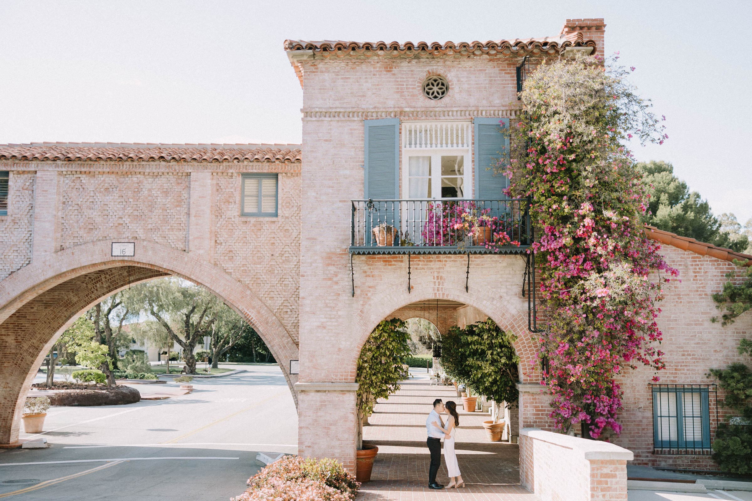 Jessie and Eric laughing together on the Palos Verdes cliffs with their dog Remi during their engagement session.