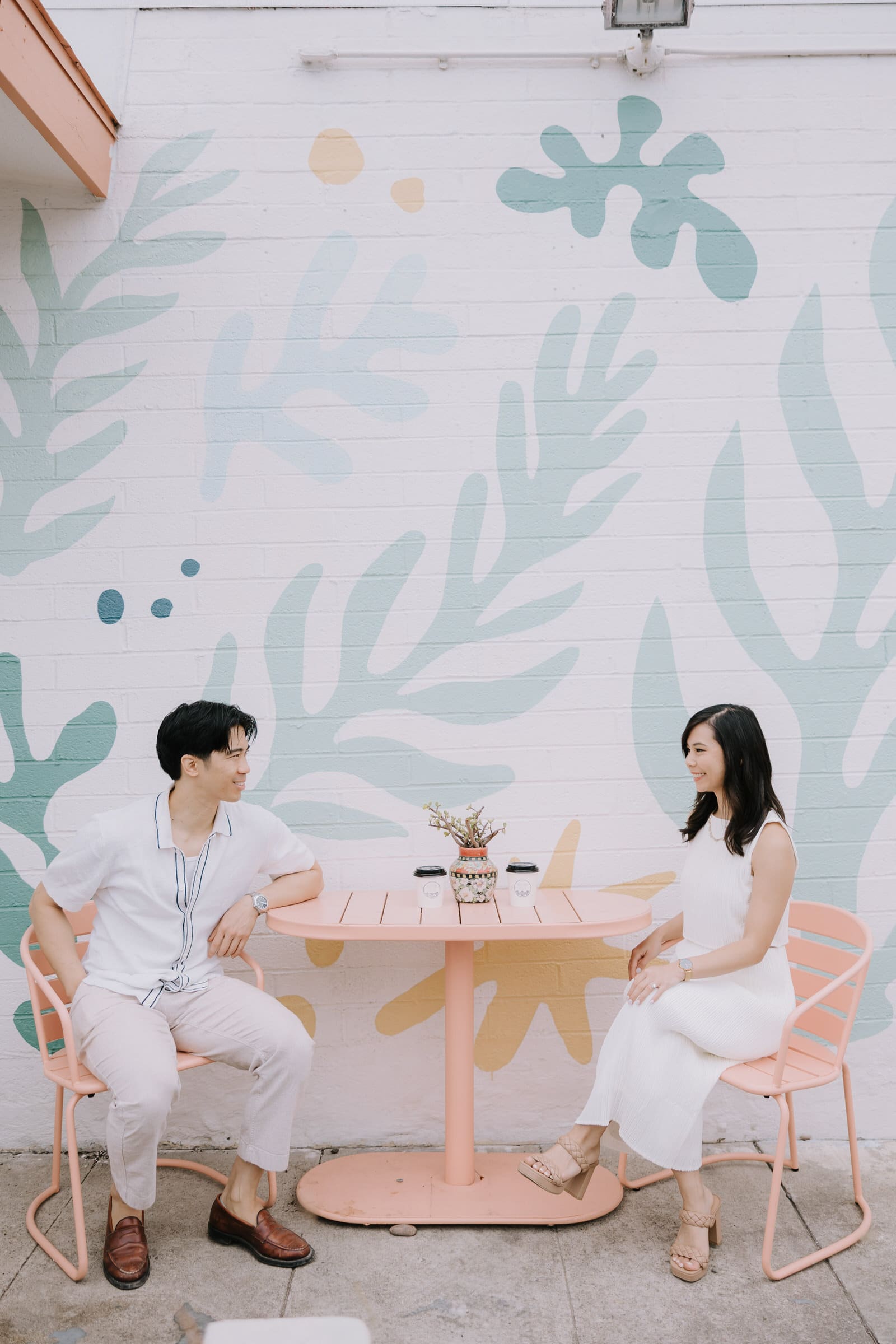 Angela and Brandon posing at San Clemente State Beach during a golden hour engagement session.