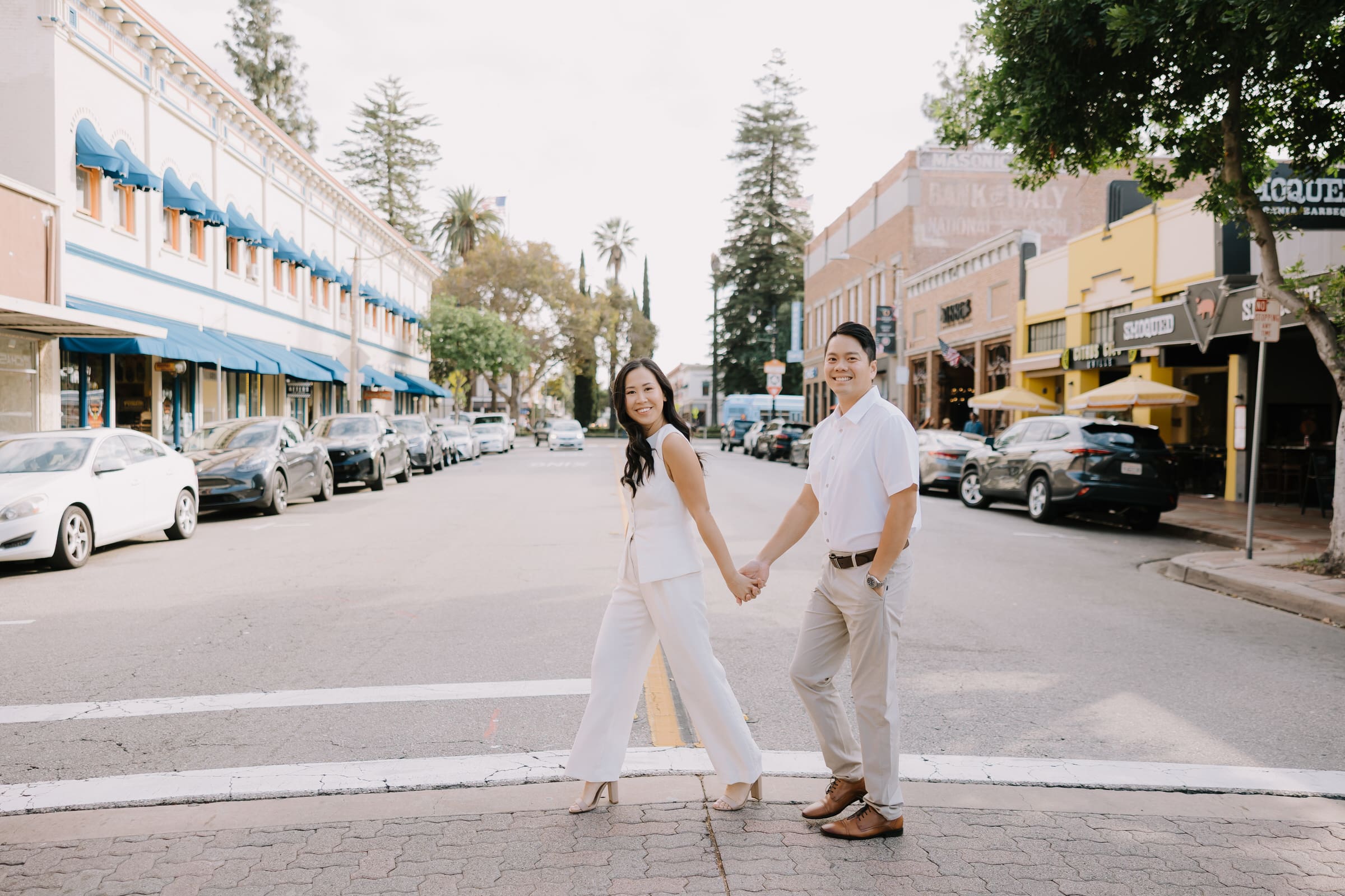 Thai and Minh walking hand-in-hand through the towering Redwood grove at Carbon Canyon Regional Park during their engagement session.