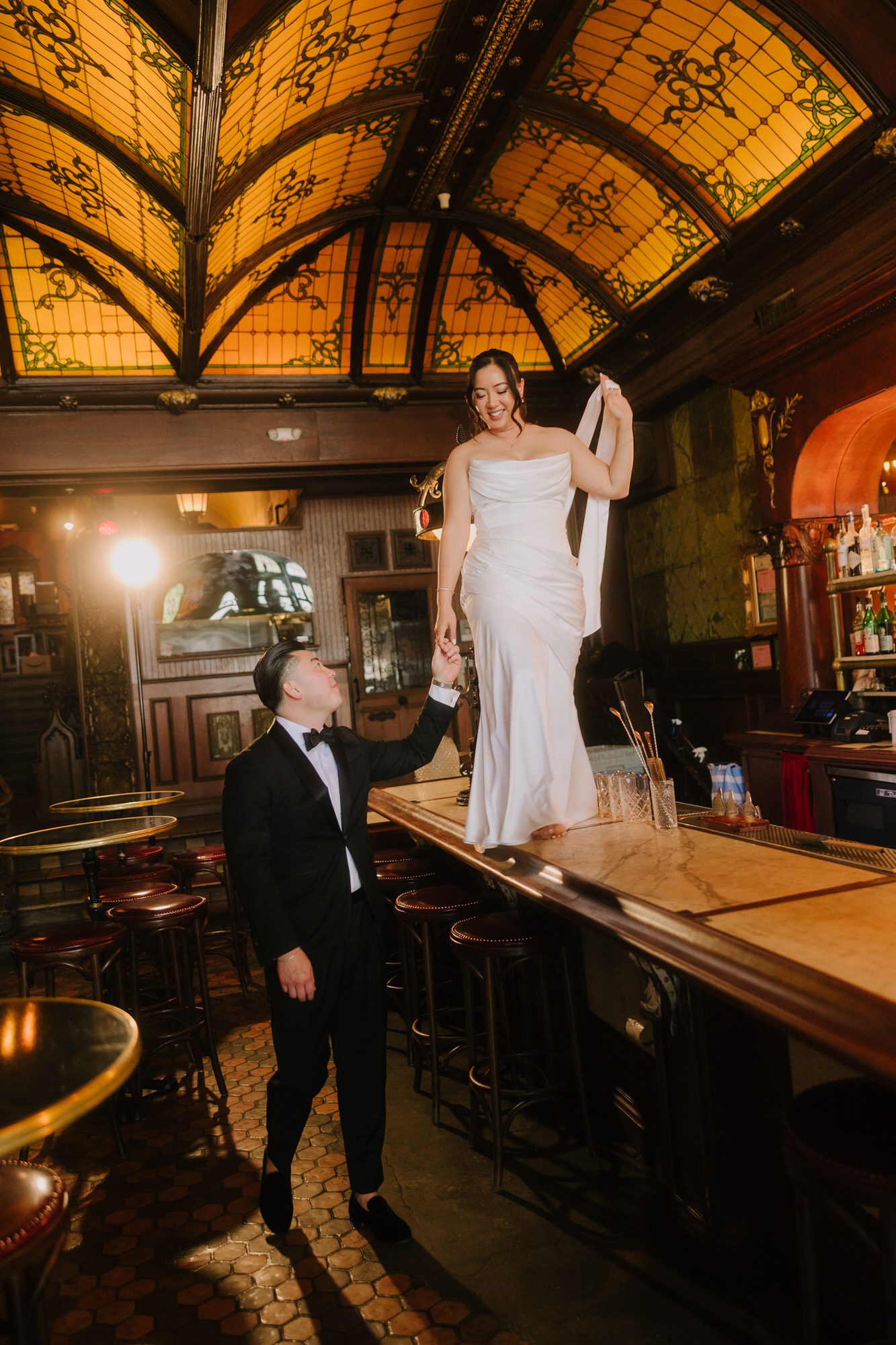 Cynthia and Stephen enjoying whiskey at a vintage marble bar inside The Wolves DTLA, featuring historic Art Deco architecture and glass ceilings.